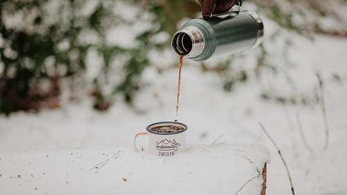 coffee cup depth photo of person holding vacuum flask filling cup portrait